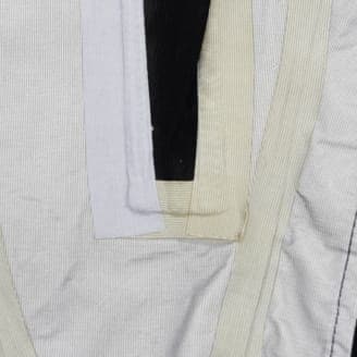 修理後の同じ衣服のクローズアップ画像。縫い目のテープがしっかりと再接着され、縫い目が完全に覆われている。