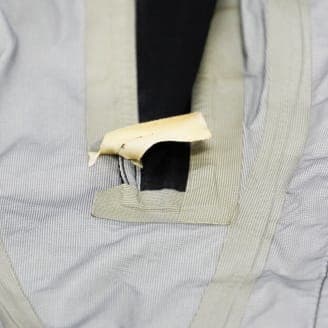 縫い目のテープが剥がれ、縫い目が露出している衣服のクローズアップ画像