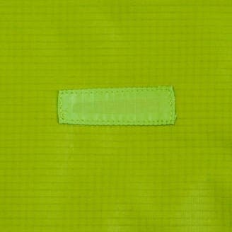 修理後の同じ緑色の生地のクローズアップ画像、裂け目が補修されており、補修用の布が縫い付けられている。